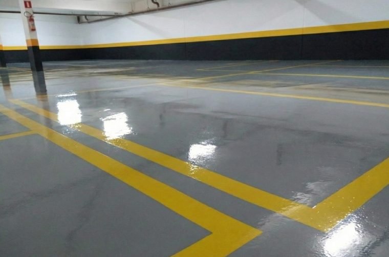 Piso de garagem com pintura epóxi cinza e faixas amarelas